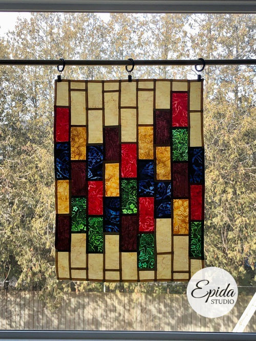 stained glass window hanging in dark colours.