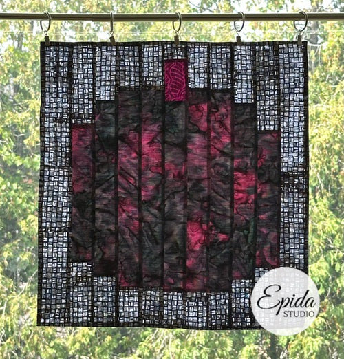 window hanging featuring a purple pumpkin on a black and white background.