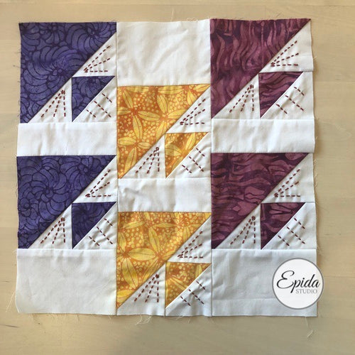 purple and gold birds in air quilt block embellished with hand embroidery.