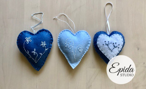 three felt ornaments with floral designs.