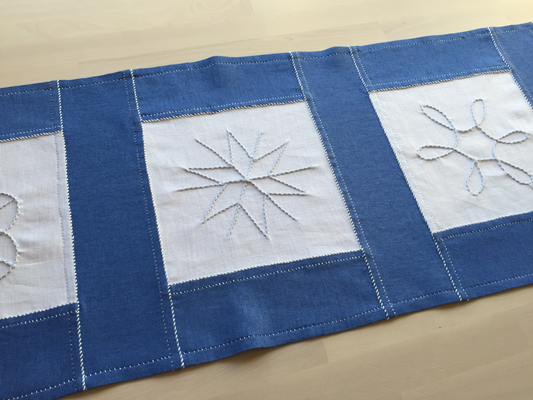 close up of stitching on embroidered snowflake table runner