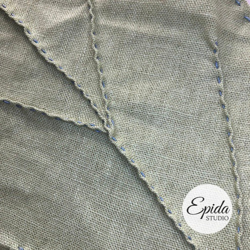 Close up of stitching on linen leaf.