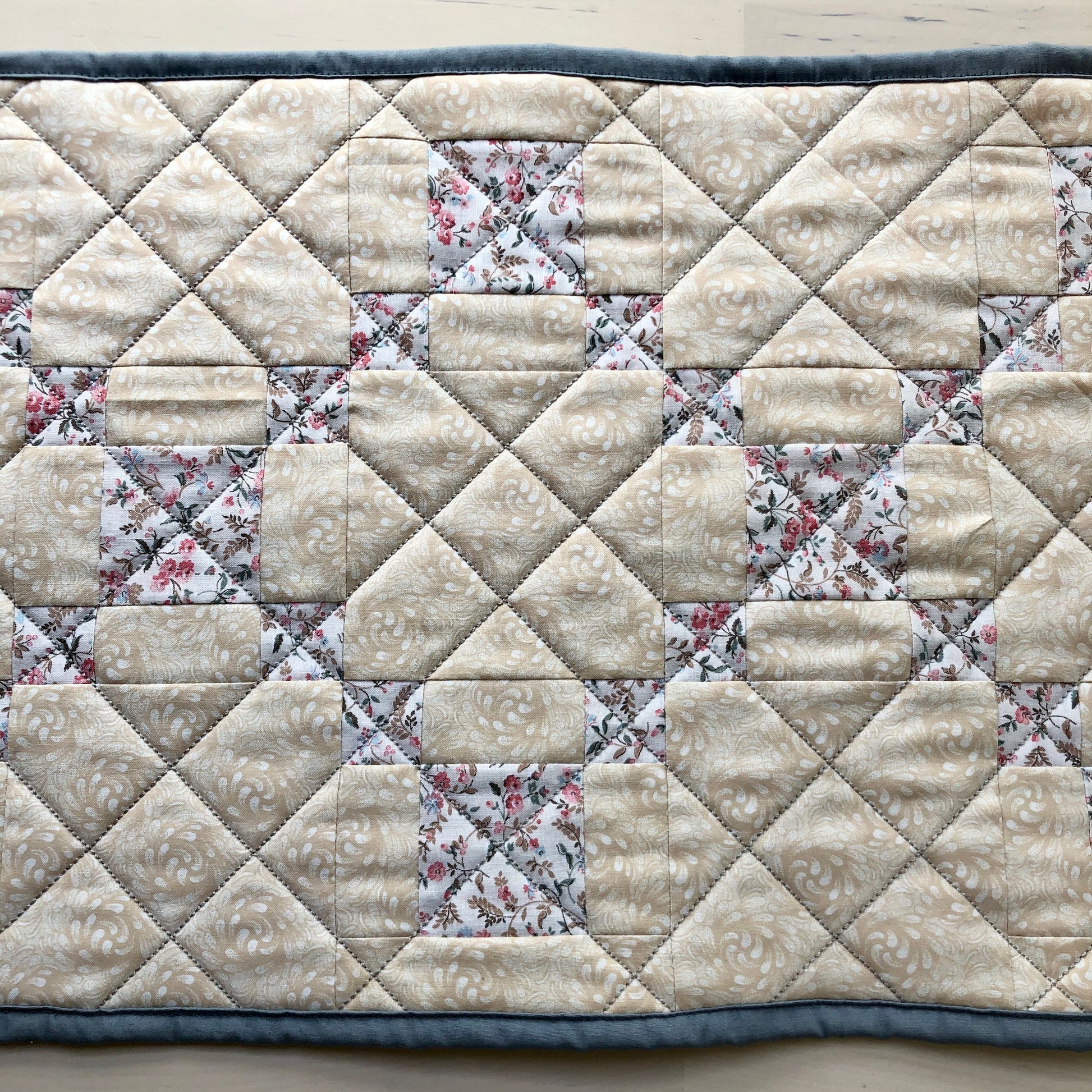 close up of diagonal line quilting on table runner.