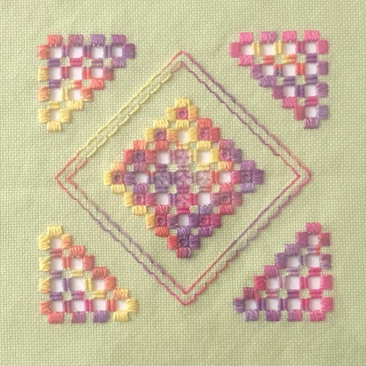 hardanger stitching with pink thread on green fabric.