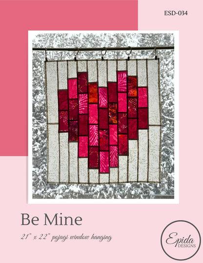Heart-shaped stained glass window hanging with pink and red colors on a white background, featuring the brand 'Epida Designs'.