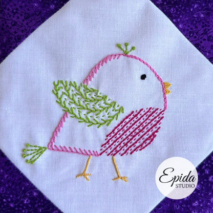 Embroidered bird design on fabric with 'Epida Studio' logo.
