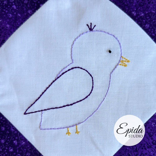 Embroidered bird design on fabric with 'Epida Studio' logo.