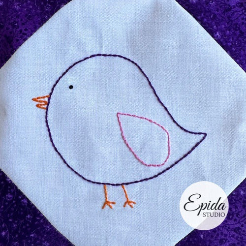 Embroidered bird design on fabric with 'Epida Studio' logo.
