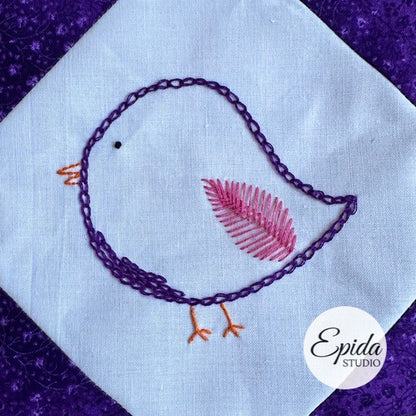 Embroidered bird design on fabric with 'Epida Studio' logo.