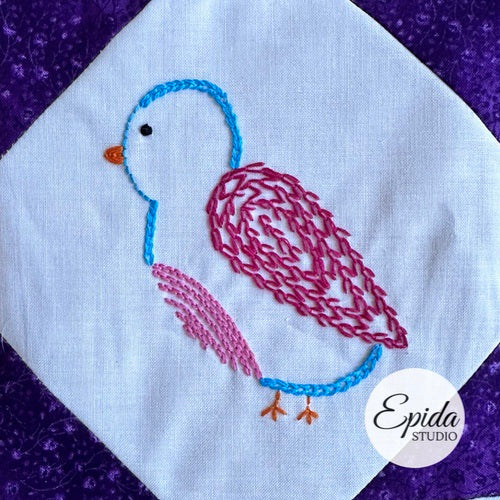 Embroidered bird design on a white fabric with a purple border, featuring the brand 'Epida Studio'.