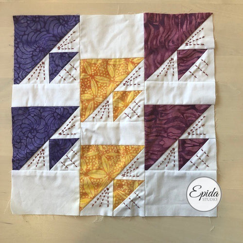purple and gold birds in air quilt block  embellished with hand embroidery.