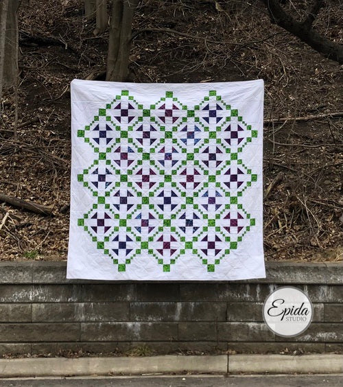 quilt with green and purple fabric on white background.