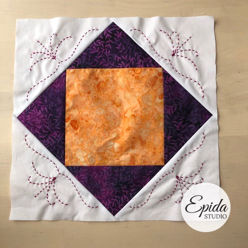 purple and orange economy quilt block embellished with hand embroidery.