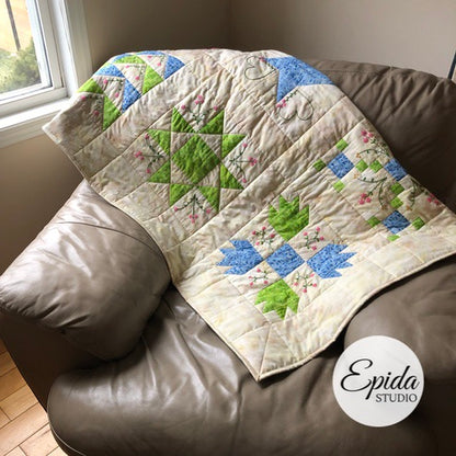 hand embroidered quilt laying on a chair.