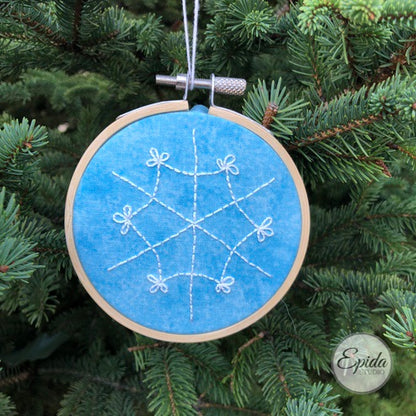 Christmas ornament with hand-embroidered snowflake.