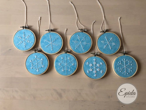 eight hand embroidered snowflake ornaments.
