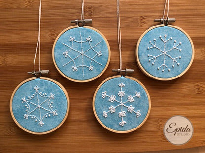 four embroidered snowflakes in hoops.