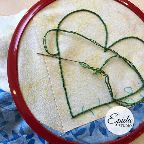 embroidering on quilt block.