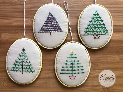 four embroidered Christmas tree ornaments.