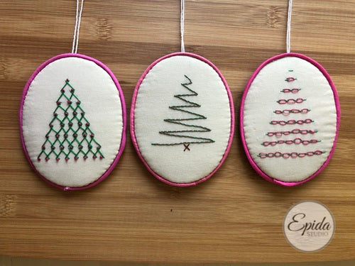three embroidered Christmas tree ornaments.