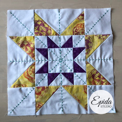 gold and purple double sawtooth star quilt block.