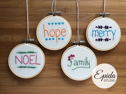 four hand embroidered ornaments with Christmas words.