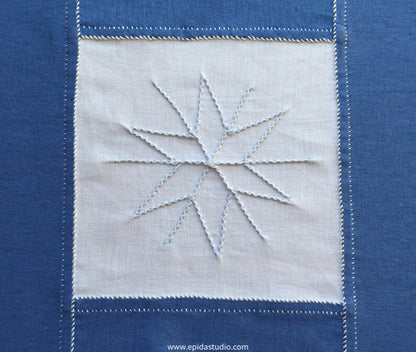 close up of pointy snowflake on embroidered table runner
