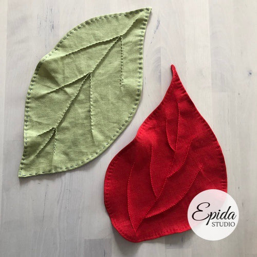 Red and green leaves hand stitched out of linen fabric.