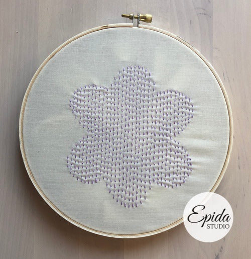 embroidered flower on white fabric.