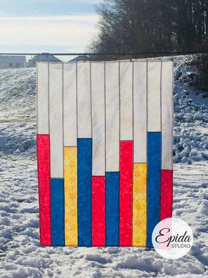 blue, red and yellow pojagi patchwork piece outside in the snow.