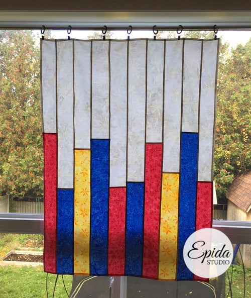 reversible patchwork window hanging with blue, red and yellow bars.