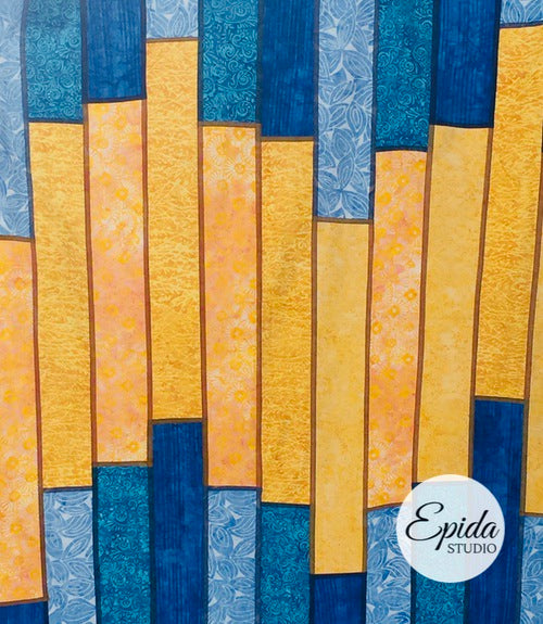 close up of fabric on blue and yellow reversible patchwork window hanging.