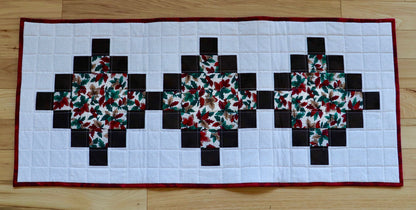 quilted table runner with brown chain and floral fabric.