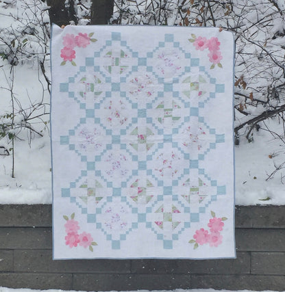 quilt with blue and pink fabric on white background.