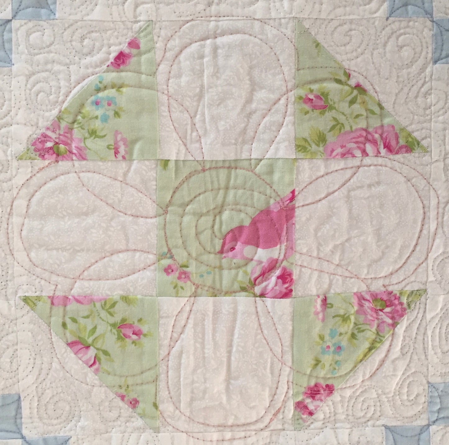 close up of shoo fly quilt block with flower quilting.